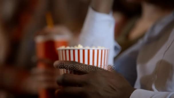 Detail Mísa plná popcornu. Africký muž jí v kině s jeho přáteli.