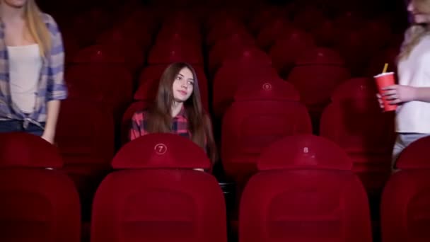 Friends go to the hall cinema for movies. Big screen and red chairs. — Stock Video