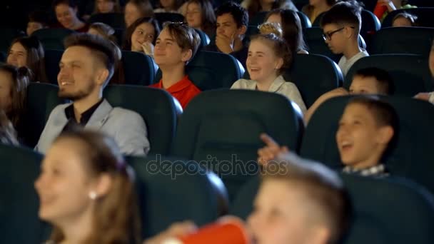 Діти з ентузіазмом виглядають веселим мультфільмом у кінозалі. Молодий батько зі своїм тістом . — стокове відео