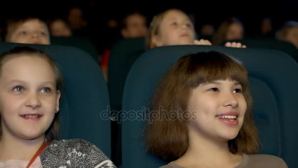 Lächelndes kleines Mädchen, das sich im Kino einen Film ansieht und Cola trinkt, aus nächster Nähe. — Stockvideo