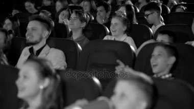 Çocuklar heyecanla neşeli çizgi film sinema salonunda arıyorum. Onun kızı ile genç baba. Siyah ve beyaz vurdu.