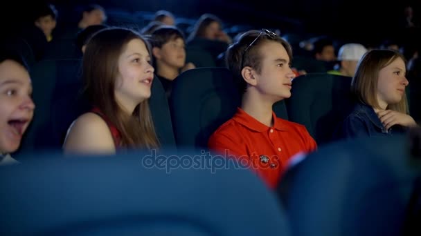 Famille avec de beaux adolescents et amis regardant un dessin animé drôle au cinéma . — Video