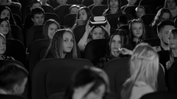 Μικρά κορίτσια και αγόρια στο σινεμά βλέποντας στο αγόρι στα γυαλιά εικονικής πραγματικότητας. Μαύρο και άσπρο φιλμ. — Αρχείο Βίντεο