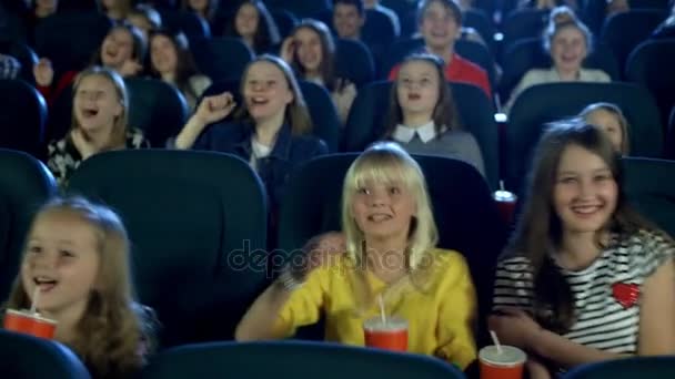 Дети в кинотеатре смотрят очень смешные мультфильмы. Они едят попкорн и пьют колу. . — стоковое видео