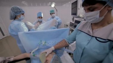 Cerrahlar performans gösteren Cerrahi operasyon, Operasyon odası takım. Genç bir kız profesyonellerinden oluşan bir ekip yapar ameliyat.