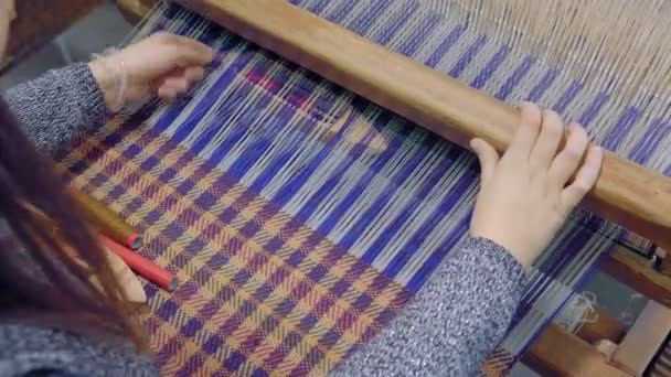 Chica intenta hilos de lana blanca a través de alambre de telar, de cerca. Tejiendo con en telar, demostración de la técnica. Filmación de arriba, 4K . — Vídeo de stock