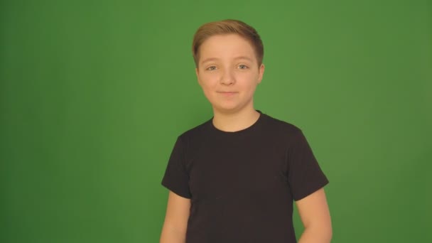 De emoties van de kinderen, portret van gelukkige jongen camera kijken. 4k, jongen op een groene achtergrond — Stockvideo