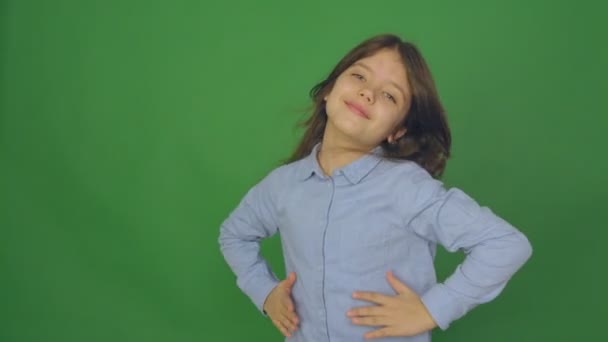Pozitivní krásná dívka mluví do kamery s úsměvem na zelené obrazovce, dívka s vlasy rozptyl — Stock video