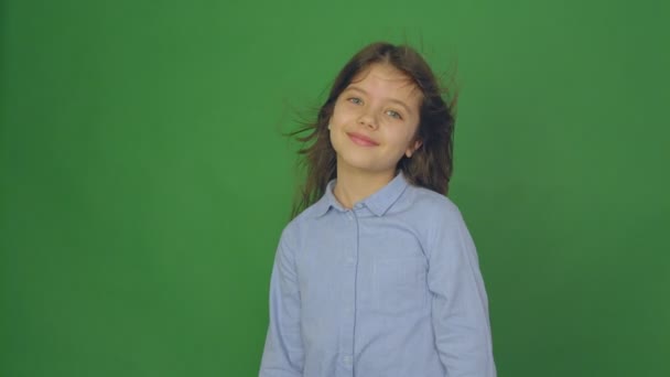 Positive beautiful girl talking to a camera with a smile on a Green Screen, girl with scattering hair — Stock Video