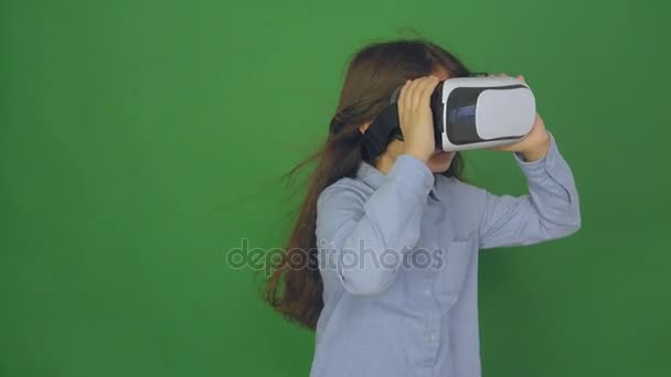 Høykvalitetsvideo av barn med virtuelle virkelighetsbriller. Lykkelig jente i virtuelle virkelighetsbriller. Liten jente med grønn bakgrunn, kamera i 4K. . – stockvideo