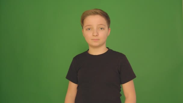 Un bel ragazzo mostra emozioni diverse su uno sfondo verde. Fotocamera in 4K . — Video Stock