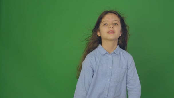 Positive beautiful girl talking to a camera with a smile on a Green Screen, girl with scattering hair, slow motion. — Stock Video