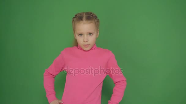 Retrato de cerca de una niña seria sobre un fondo verde . — Vídeo de stock