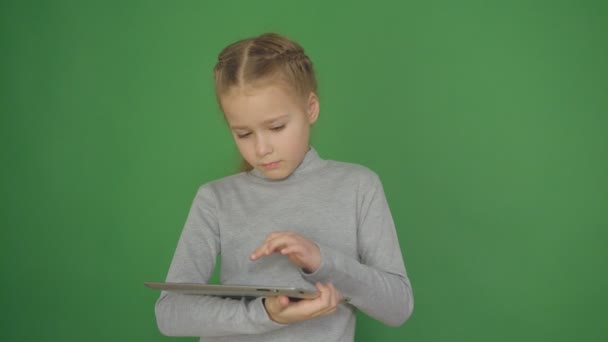 Menina jovem, concebida usando a tecnologia tablet touchscreen e leitura. 4K — Vídeo de Stock