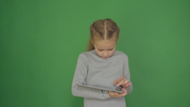 Young, bedacht meisje met behulp van touchscreen tablet-technologie en lezen. — Stockvideo