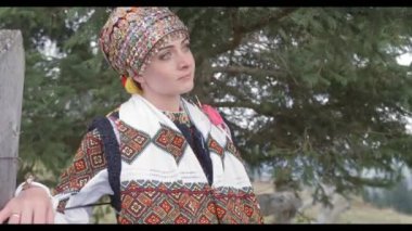 Nakışlı ulusal kostümlü mutlu genç çift sahada yürüyor. Geleneksel kıyafetlerle Ukrayna düğünü