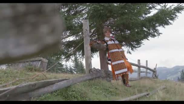 穿着绣花民族服装的年轻夫妇在田野里散步，他们恋爱了，快乐了 — 图库视频影像