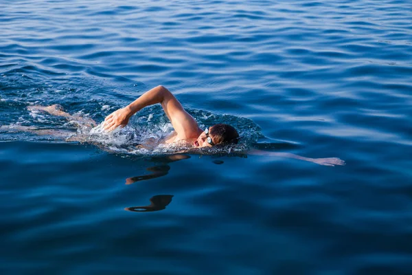 Homme nageant dans l'eau bleue — Photo