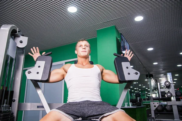 Atleta haciendo ejercicio de pecho en la máquina en el gimnasio — Foto de Stock