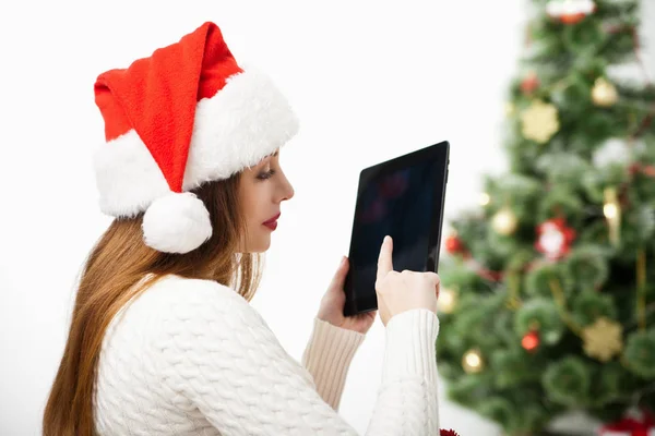 Frau sitzt mit Tablet-PC über Weihnachtsbaum — Stockfoto