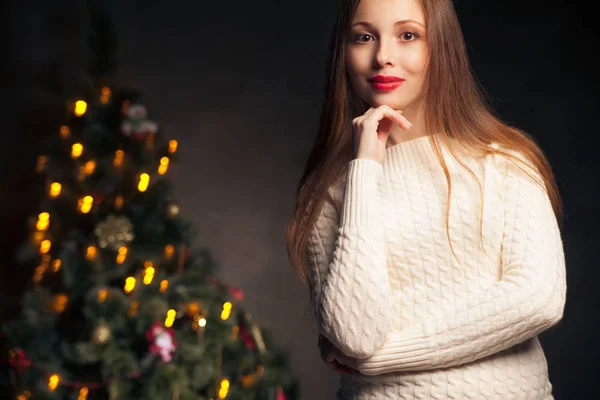 Mujer sonriente frente al árbol de navidad —  Fotos de Stock