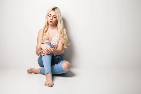 Jeune blonde assise sur le studio — Photo