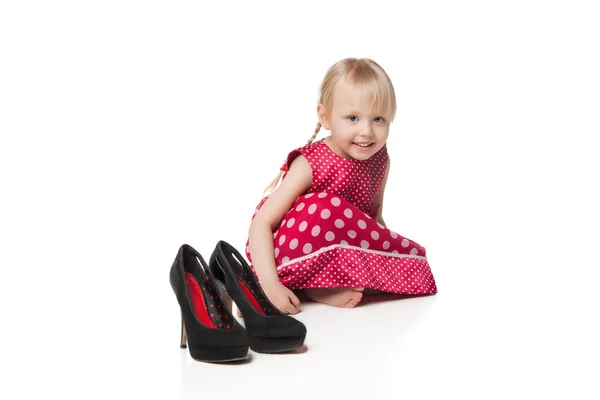 Smiling little girl with big shoes — Stock Photo, Image