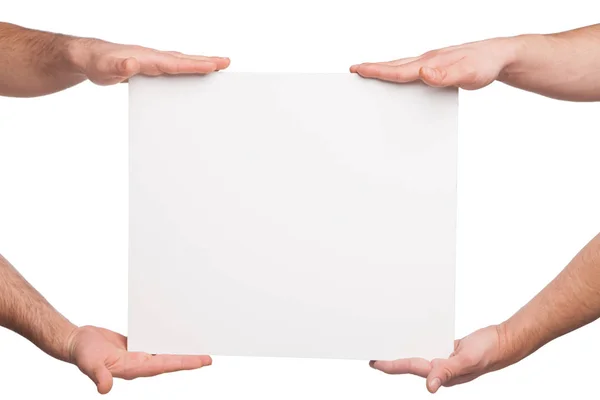 Quatro mãos segurando uma placa branca em branco — Fotografia de Stock
