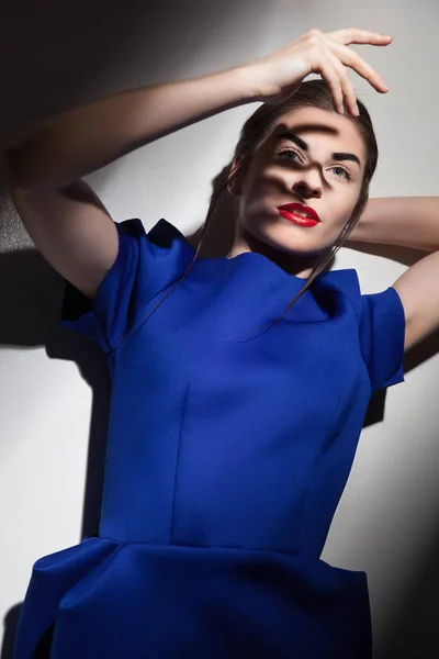 La mujer a la moda que se encoge la cara de la luz —  Fotos de Stock