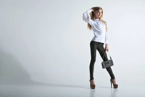 Mulher na moda com uma bolsa em fundo leve — Fotografia de Stock