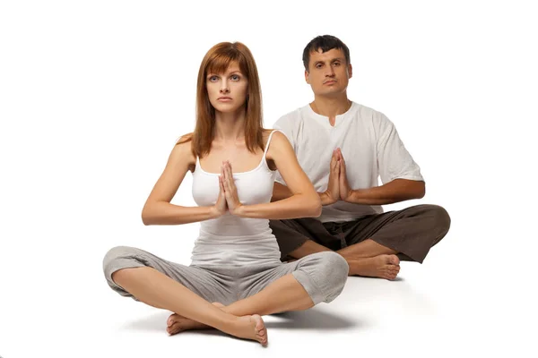 Pareja sana en posición de yoga sobre blanco — Foto de Stock