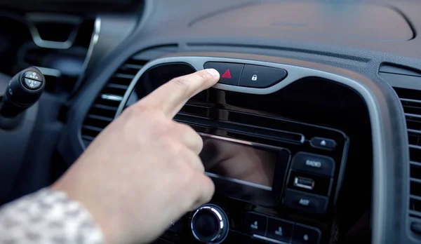 Mano masculina pulsando el botón de advertencia de emergencia en la consola del coche — Foto de Stock