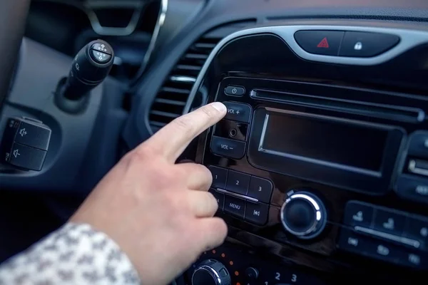 Un homme appuyant sur le bouton sur le tableau de bord tout en conduisant une voiture — Photo