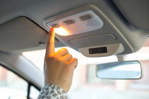 Мужчина включает свет на потолке в машине — стоковое фото