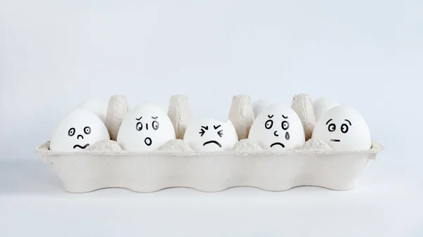 Яйця з кумедними обличчями в упаковці на білому тлі. Великдень Концепція Фото. Обличчя на яйцях — стокове фото