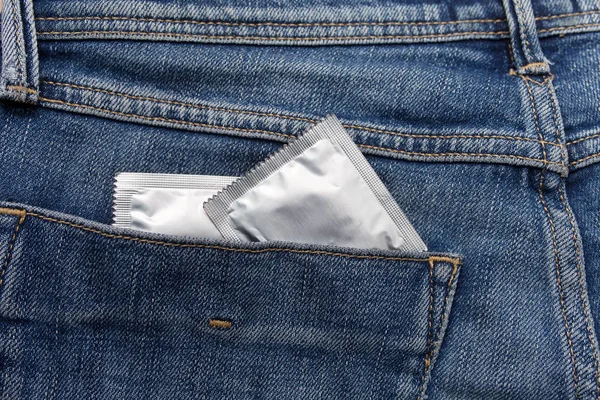 Condón de color plata en el bolsillo de un vaquero azul — Foto de Stock