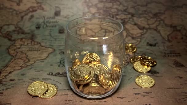Золоті монети Bitcoin потрапляють до скарбнички. — стокове відео