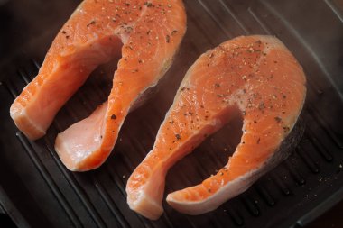 Izgarada somon hazırlama işlemi. Izgara balık biftek yanıyor. Üstten Görünüm.