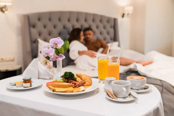 ホテルのコンセプトで卵とコーヒールームサービス 背景にぼやけたカップル ロイヤリティフリーのストック写真
