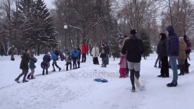 Kış günü, insanlar aktif olarak bir şehir parkında dinlenme