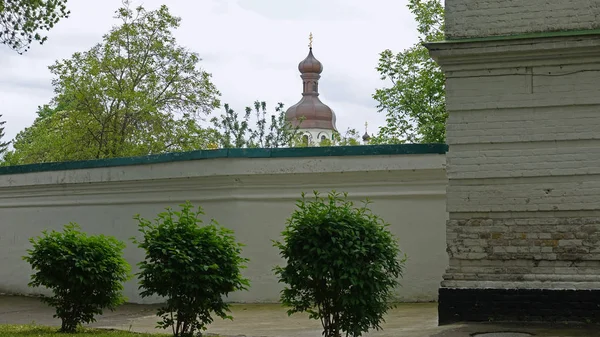 Parte da cerca de pedra na Lavra Kiev Pechersk e Torre do Relógio — Fotografia de Stock