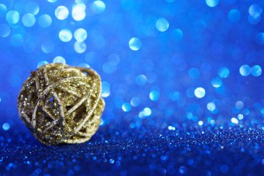 Parlak Noel ağacı oyuncağı parlak mavi bir arka planda yatıyor. Th