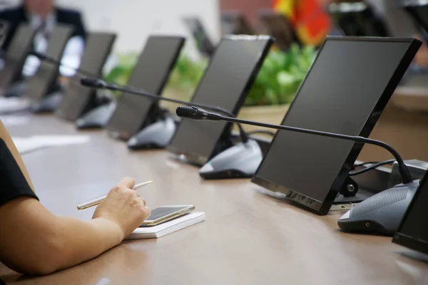 Una donna con uno smartphone, penna stilografica e notebook siede a una t — Foto Stock