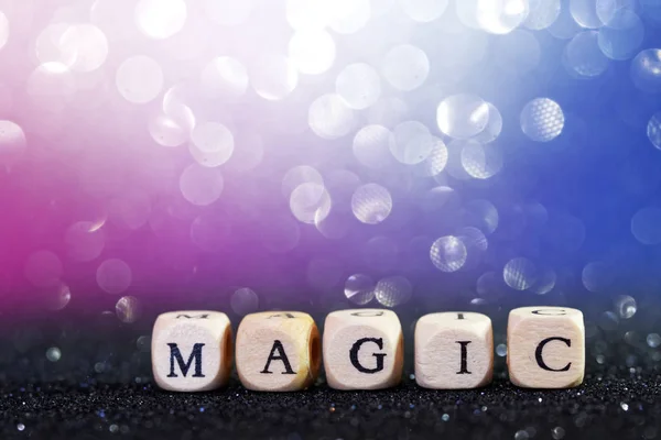 The word magic made of wooden cubes with letters. Flickering col