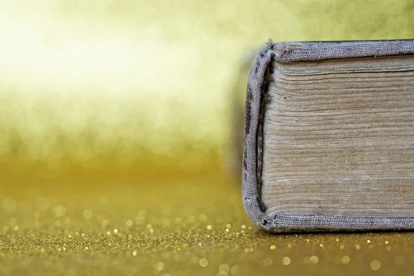 Kręgosłup starej grubej książki leży na żółtym tle. Libr — Zdjęcie stockowe