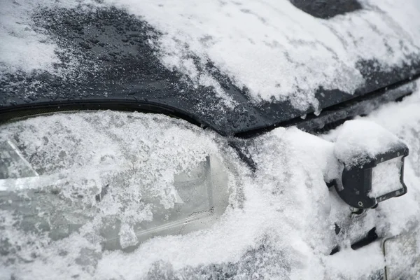Faros cubiertos de nieve de un auto todoterreno. Tormenta de nieve y carretera — Foto de Stock