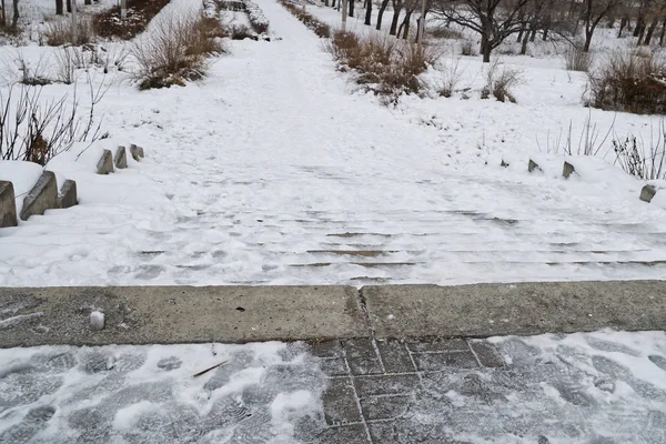 Escalera de hormigón cubierta de nieve en un parque de la ciudad vieja. Peligroso d — Foto de Stock