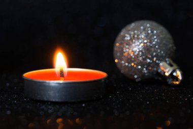 Yanan Noel mumları ve parlak toplar karanlık arka planda. 