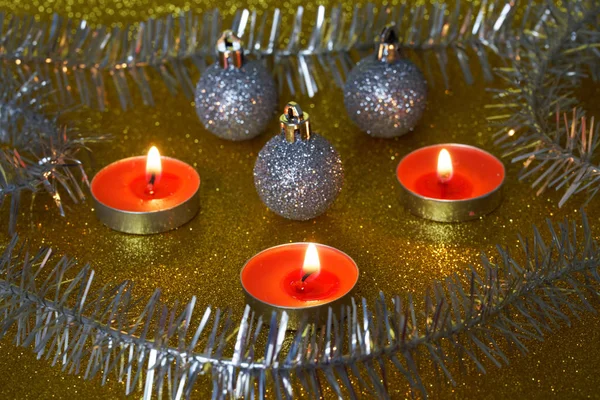 Kerst kaarsen, knutselen en speelgoed branden op een gouden glanzende bac — Stockfoto