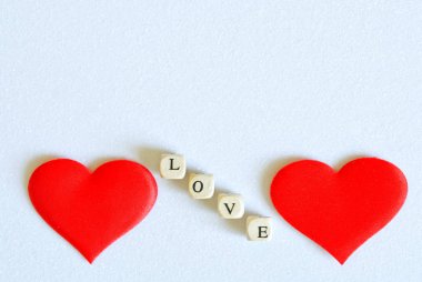 İki kırmızı ipek kalp ve beyaz bir parıltıda yazılı aşk.